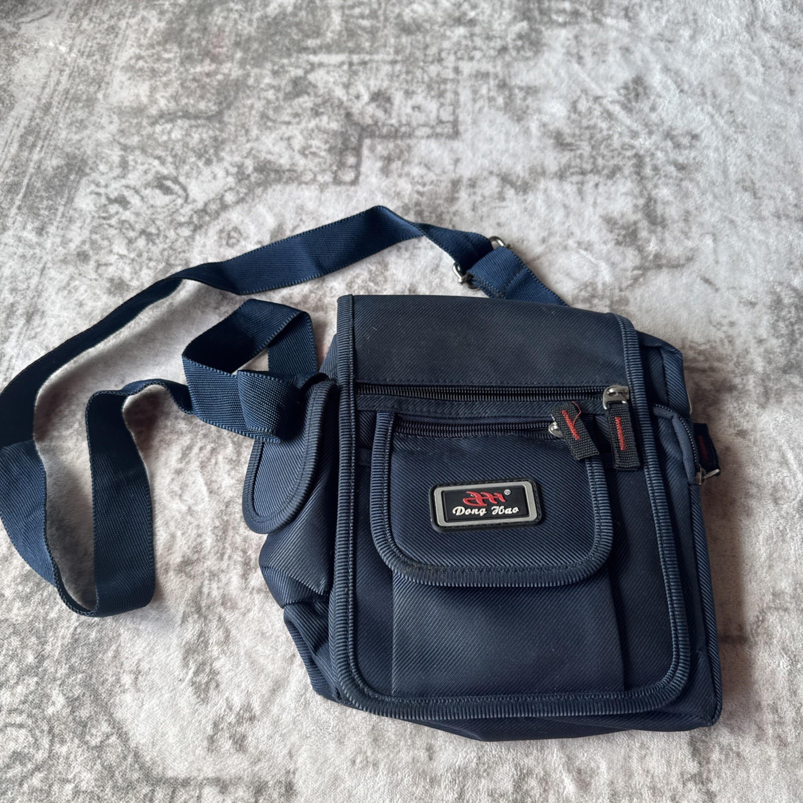 Lu Dong Hao branded small backpack featuring zippered compartments.