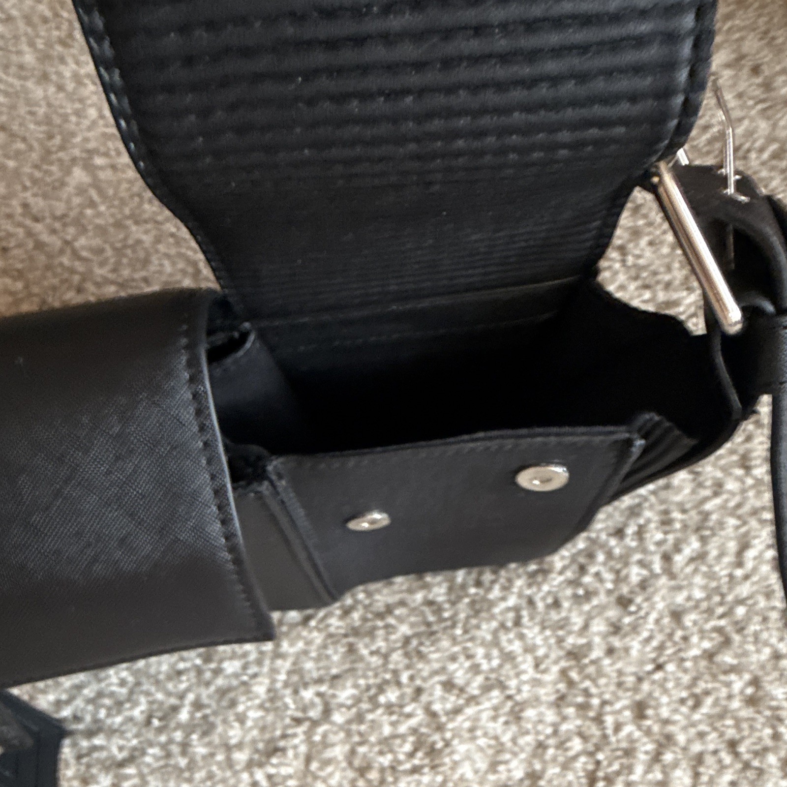 Maniere de voir Black leather shoulder bag with silver hardware and buckle strap